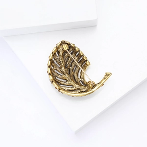 Detailed back view of vintage gold leaf brooch showing pin fastener and alloy texture
