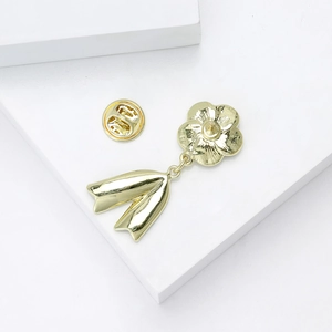 Detail view of the gold alloy camellia brooch back showing the pin and butterfly clasp mechanism