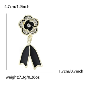 Elegant gold camellia brooch with black enamel, sparkling rhinestones and ribbon pendant