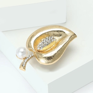Detail of leaf brooch with brushed gold finish, white pearl and sparkling crystals