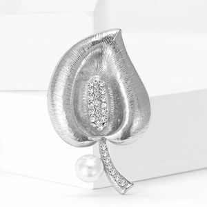 Detail of silver leaf brooch with sparkling zircons and a glossy white pearl accent