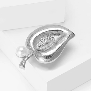 Detailed close-up of silver calla lily leaf brooch with pearl and sparkling rhinestones
