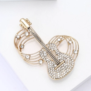 Macro shot of guitar brooch featuring sparkling rhinestones and golden musical curves