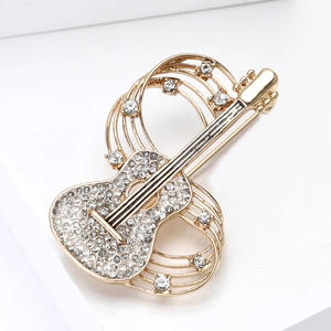 Close-up of guitar brooch with sparkling rhinestones and gold plating detail