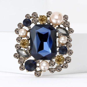 Broche carrée vintage avec cristal bleu foncé et perles sur un socle élégant