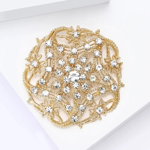Detailed macro view of vintage hollow round brooch with sparkling rhinestones and gold finish