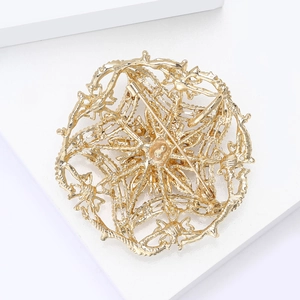 Detailed back view of vintage hollow gold brooch showing pin fastener and lace texture