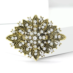 Macro detail of luxury vintage flower brooch with white crystals and gold alloy finish