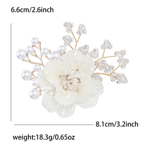 Detalle del broche de flor blanca tejida con perlas y dimensiones 8,1cm x 6,6cm