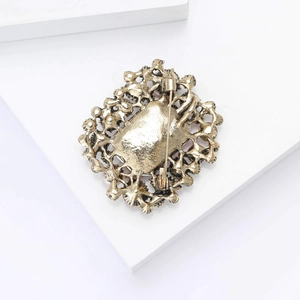 Vue détaillée du dos d'une broche vintage en alliage doré antique avec épingle de sûreté