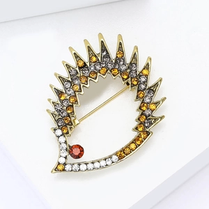 Macro shot of cartoon hedgehog brooch with colorful rhinestones on gold alloy plating