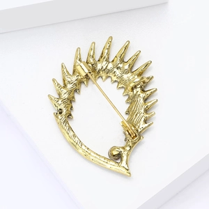 Detail view showing the vintage gold alloy hedgehog brooch back with safety pin closure