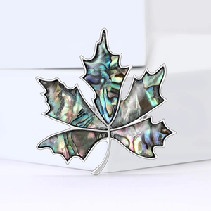 Elegant maple leaf brooch with colorful abalone shell inlay on white block
