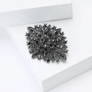 Close-up of vintage flower brooch in gun-black alloy with intricate black crystal inlay