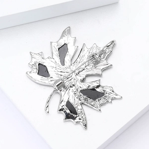Elegant silver maple leaf brooch with black enamel inlay and secure pin clasp closure