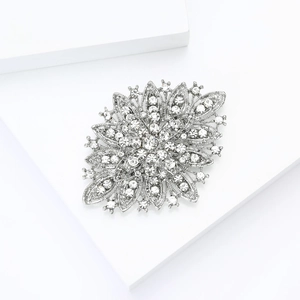 Macro shot of silver crystal flower brooch with sparkling rhinestones on white display