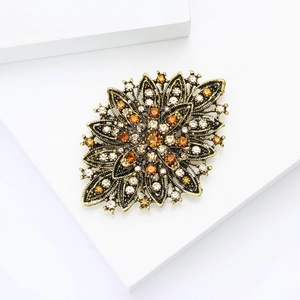 Close-up of vintage flower brooch with amber rhinestones and bronze alloy petals