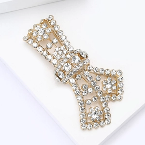 Detailed view of the gold-plated alloy ribbon brooch with sparkling clear rhinestones