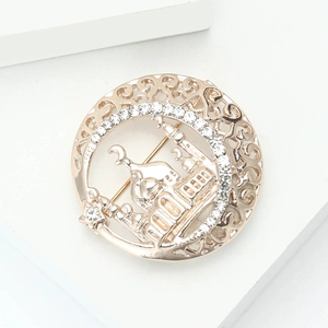 Detail of a vintage golden Taj Mahal brooch with sparkling rhinestones and moon symbol