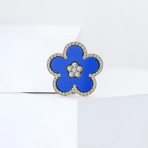 Detailed close-up of periwinkle flower brooch with blue enamel and sparkling crystals