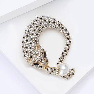 Detailweergave van luxe luipaardbroche met witte strassteentjes en een grote parel