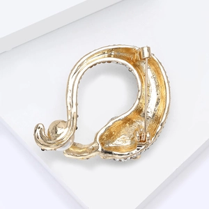 Detailaanzicht van de achterkant van een gouden zwaanbroche met veiligheidsspeld en kristallen