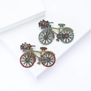 Creative bicycle brooch set with colorful rhinestones on a white geometric background