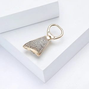 Detailed view of gold soda tab brooch with rhinestones on white minimalist display
