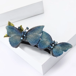 Elegant blue gradient butterfly hair clip with embroidery and beads on a white pedestal