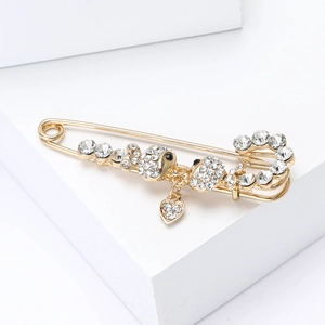 Detail of gold alloy safety pin brooch with sparkling rhinestones and cute sheep motifs
