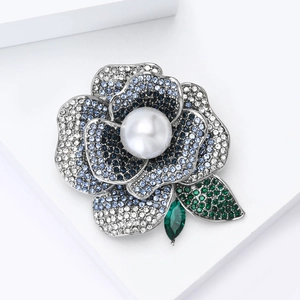 Detail of luxury rhinestone peony brooch with blue crystals and a large central pearl