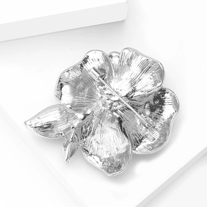 Macro shot of silver alloy peony brooch back showing safety pin clasp and textured petals