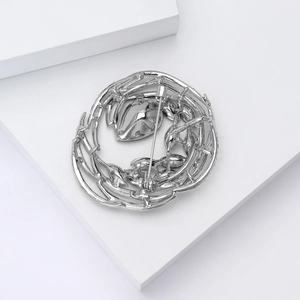 Silver bird nest brooch with a flying bird design showing the back pin closure