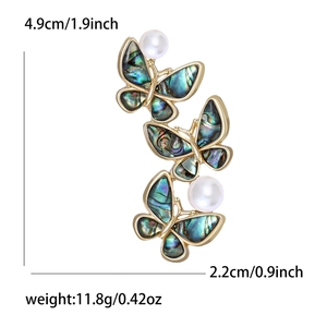 Elegant butterfly brooch with three abalone shell wings and pearl accents on white background
