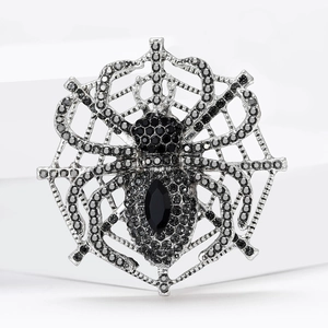 Detail view of gothic spider web brooch with black rhinestones and marquise gemstone