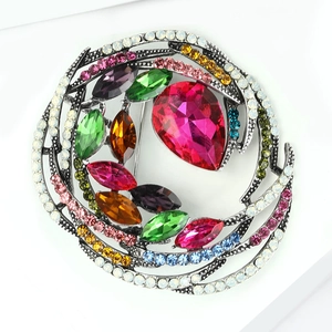 Detailed view of vintage nest brooch with colorful crystals and marquise gems on alloy