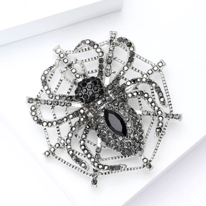 Macro shot of spider brooch with black rhinestones and intricate silver web detail