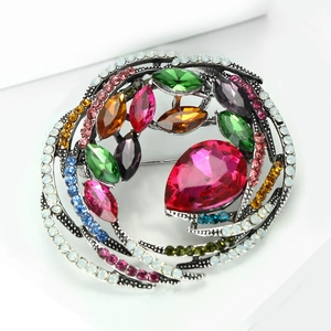 Close-up of vintage crystal bird nest brooch with colorful rhinestones on silver base