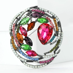 Macro shot of colorful crystal flower brooch with large red pear-shaped center gemstone