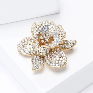 Makroaufnahme einer eleganten Blumenbrosche mit funkelnden AB-Strasssteinen und Goldlegierung