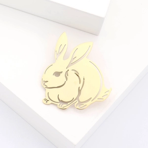 Broche lapin mignonne en acier inoxydable doré sur un décor de marches blanches élégantes