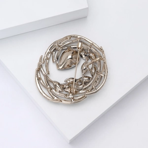 Macro shot of bird nest style crystal brooch with intricate interlaced branch design
