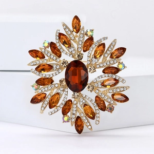 Elegant gold-tone flower brooch featuring amber crystal center and sparkling rhinestones