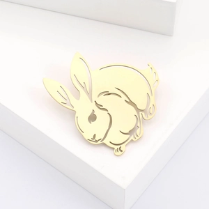 Vue détaillée d'une broche lapin dorée avec un design en métal sculpté et ajouré