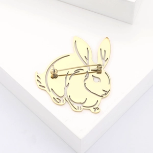 Vue détaillée d'une broche lapin dorée ajourée avec fermoir à épingle sécurisé