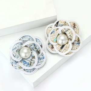Elegant 14k gold tweed flower brooch with pearl center on white geometric stairs