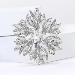 Close-up of luxury flower brooch with radiant rhinestones and a large oval center crystal