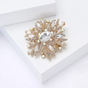 Detailed macro view of gold snowflake brooch with large oval crystal and rhinestones