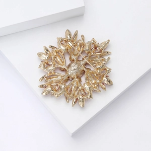 Detail view of the back of a luxury gold flower brooch showing the secure pin safety clasp