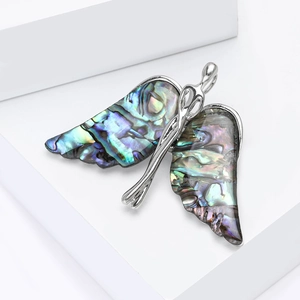 Elegant butterfly brooch in silver-tone alloy with iridescent shell wing inlay on white base